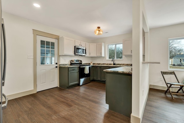1024 Hurst St, Chattanooga, TN 37412 - kitchen featuring appliances with stainless steel finishes, dark wood finished floors, recessed lighting, white cabinetry, and baseboards