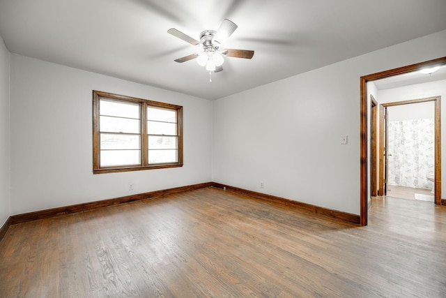 empty room with ceiling fan, baseboards, and wood finished floors