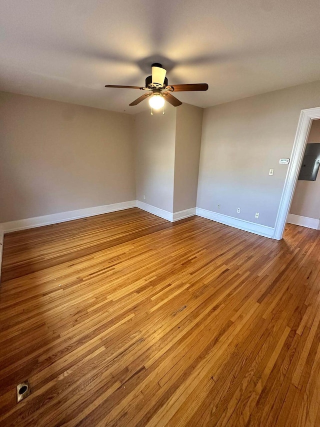 spare room featuring ceiling fan, baseboards, and wood finished floors