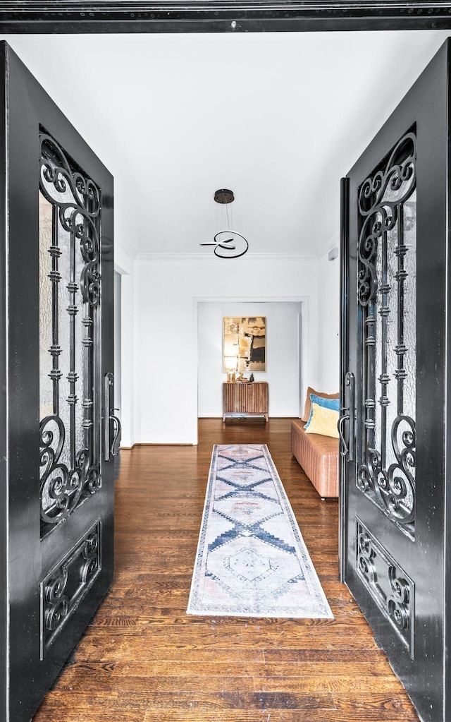 entrance foyer with crown molding and wood finished floors