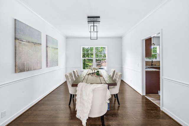 dining room with crown molding, baseboards, and dark wood-style floors