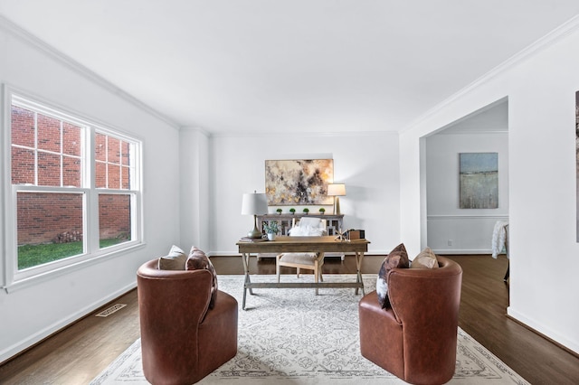 office space featuring visible vents, baseboards, crown molding, and wood finished floors