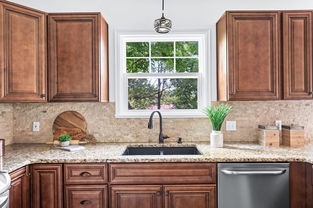 kitchen with light stone counters, tasteful backsplash, a sink, and dishwasher