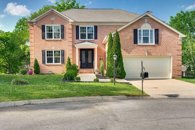 view of front of property featuring a front yard, french doors, brick siding, an attached garage, and driveway
