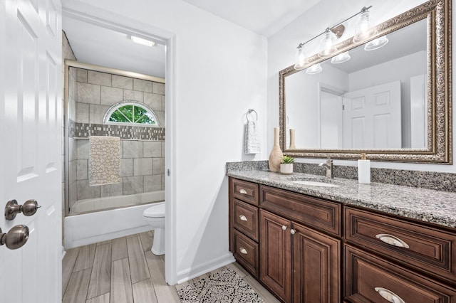 bathroom with baseboards, vanity, toilet, and shower / bath combination with glass door