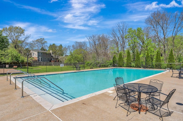 community pool with a patio and fence