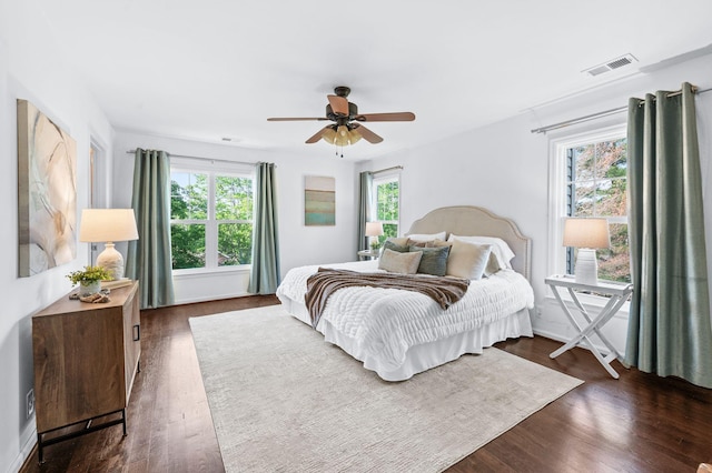 bedroom with ceiling fan, dark wood finished floors, and visible vents