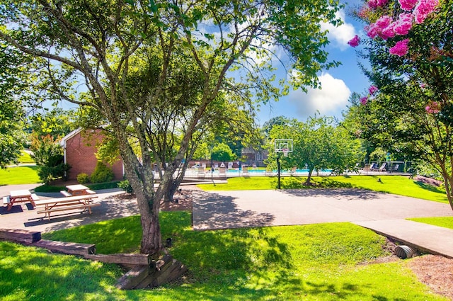 view of home's community with a lawn, a swimming pool, and playground community