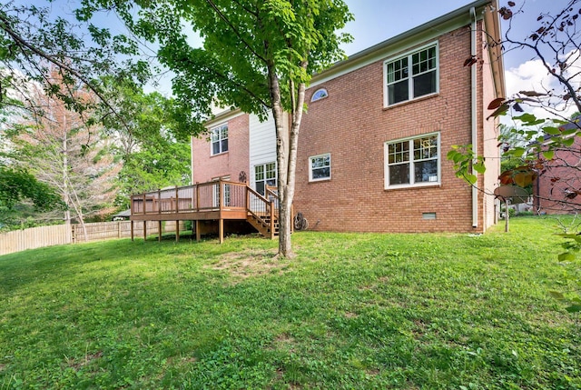 back of house with fence, a yard, and a deck