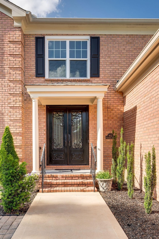 doorway to property with brick siding and french doors