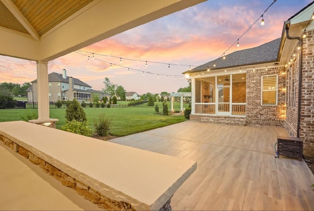 8119 Schweitzer Pl, Arrington, TN 37014 - patio terrace at dusk featuring a sunroom and a yard