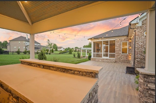 8119 Schweitzer Pl, Arrington, TN 37014 - patio terrace at dusk featuring a lawn and a sunroom