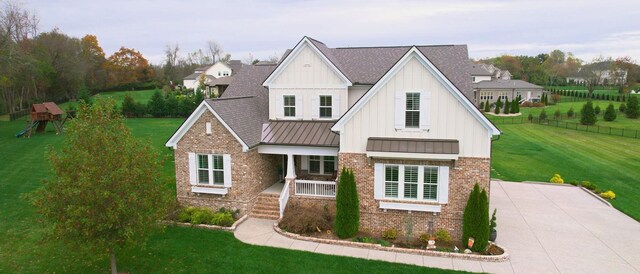 8119 Schweitzer Pl, Arrington, TN 37014 - view of front facade with a standing seam roof, a front yard, a porch, and brick siding