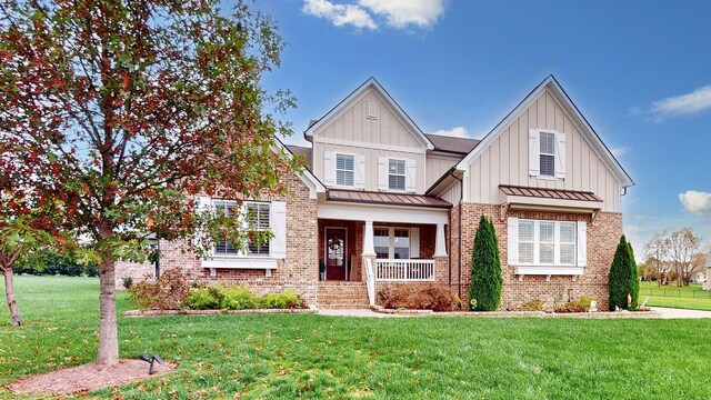 8119 Schweitzer Pl, Arrington, TN 37014 - craftsman inspired home featuring covered porch, brick siding, a standing seam roof, and a front lawn