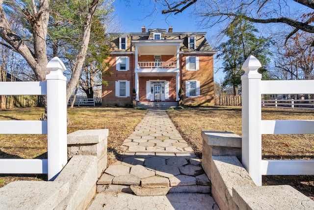 207 Dunlap St, Paris, TN 38242 - view of front of house featuring fence, brick siding, and a balcony