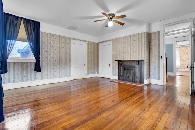 207 Dunlap St, Paris, TN 38242 - unfurnished living room featuring wood-type flooring, baseboards, ceiling fan, and wallpapered walls