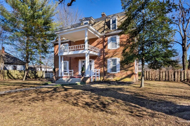 207 Dunlap St, Paris, TN 38242 - victorian home featuring fence, a chimney, brick siding, and a balcony