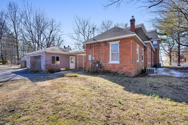 207 Dunlap St, Paris, TN 38242 - back of house featuring brick siding, a shingled roof, central AC, and a chimney