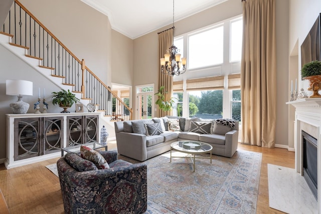 living area featuring a healthy amount of sunlight, a high ceiling, stairs, and wood finished floors