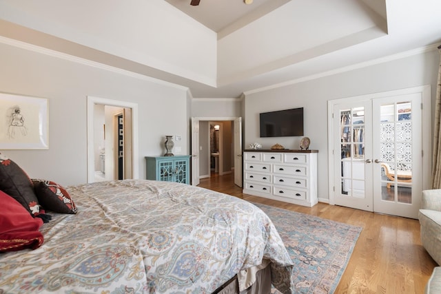 bedroom with crown molding, connected bathroom, a raised ceiling, french doors, and wood finished floors