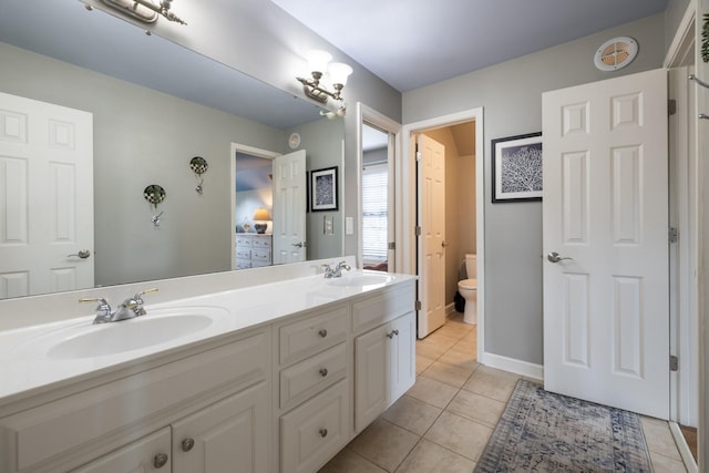 bathroom with double vanity, toilet, tile patterned floors, and a sink