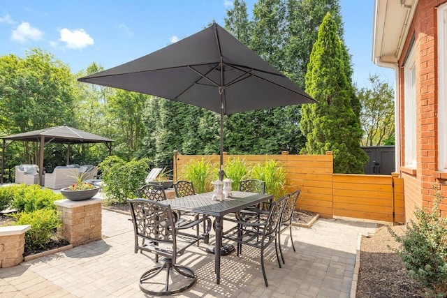 view of patio / terrace featuring a gazebo, fence, and outdoor dining area