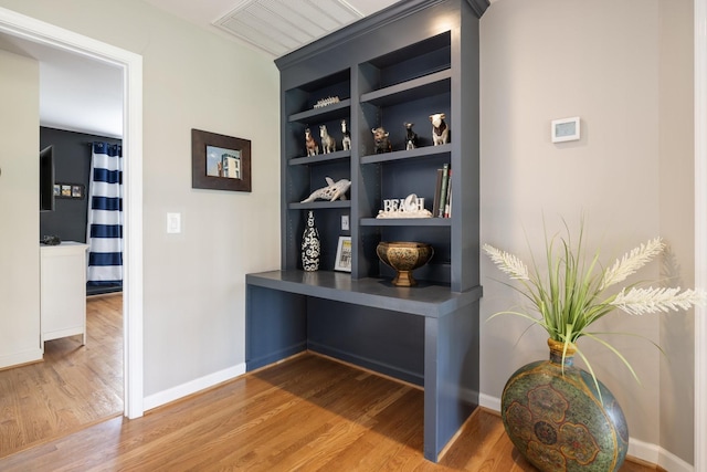 room details featuring baseboards, wood finished floors, visible vents, and built in shelves