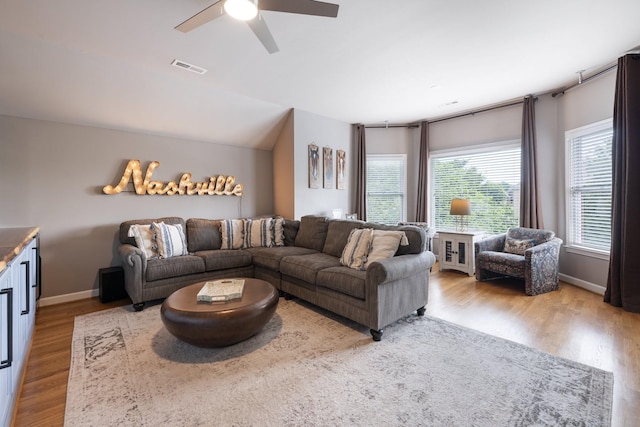 living area featuring visible vents, baseboards, ceiling fan, and wood finished floors