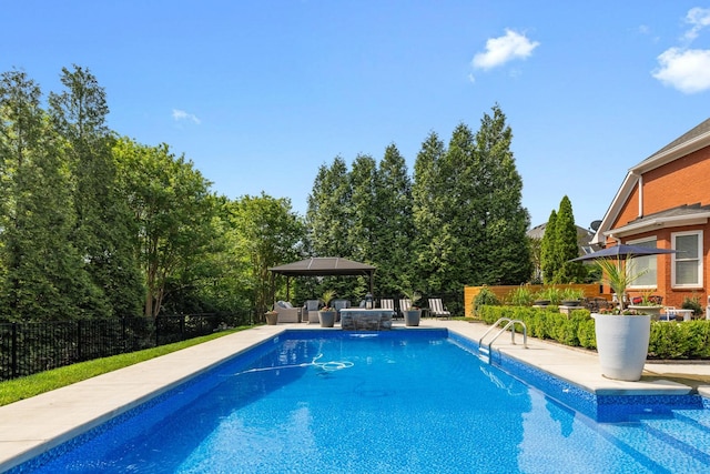 view of swimming pool featuring a gazebo, fence, a fenced in pool, a patio, and outdoor lounge area