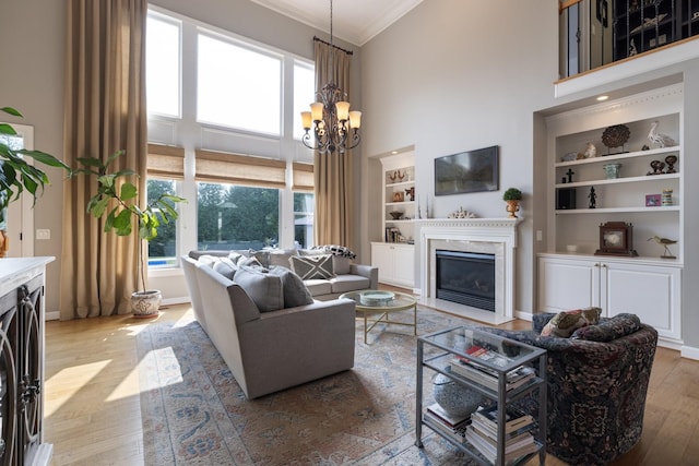 living room with a fireplace with flush hearth, built in features, and a healthy amount of sunlight
