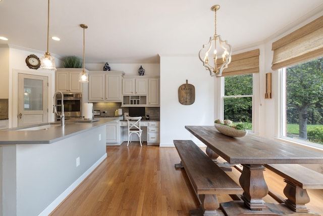 dining room with light wood-type flooring, recessed lighting, a wealth of natural light, and ornamental molding