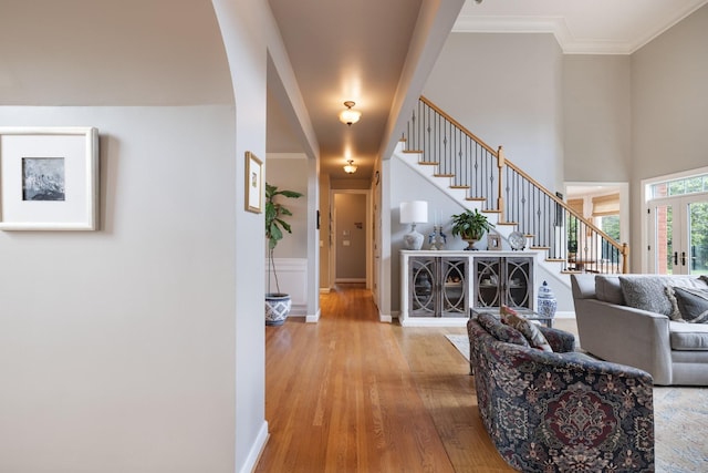 interior space featuring crown molding, baseboards, wood finished floors, and stairway