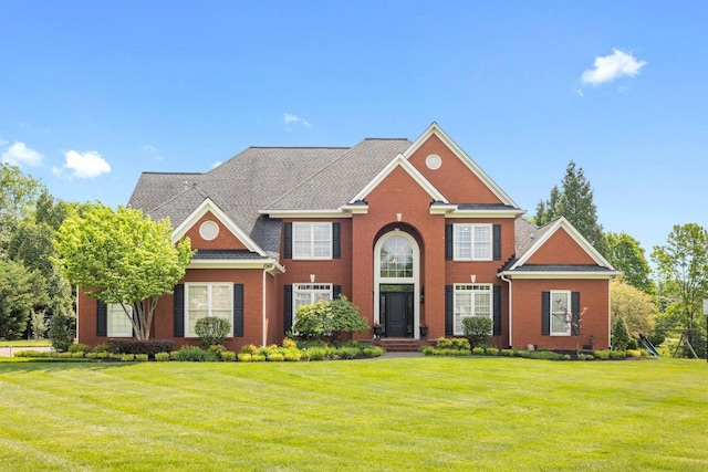 colonial-style house with brick siding and a front yard