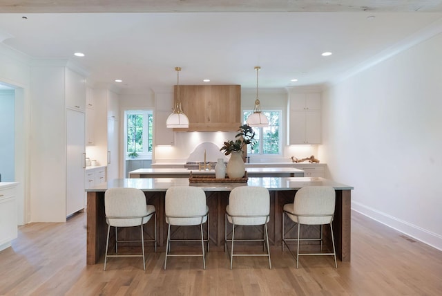 111 Keyway Dr, Nashville, TN 37205 - kitchen with a center island, light wood-type flooring, white cabinets, light countertops, and hanging light fixtures