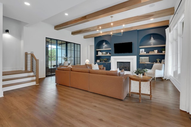 living area featuring beam ceiling, wood finished floors, stairway, baseboards, and recessed lighting