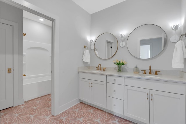 full bath with a sink, tile patterned floors, baseboards, and double vanity