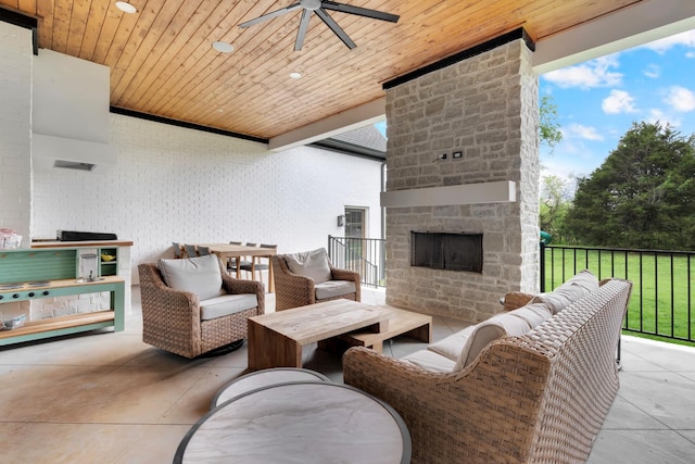 view of patio / terrace with ceiling fan and an outdoor living space with a fireplace