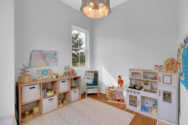 rec room featuring an inviting chandelier and wood finished floors