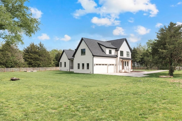 view of side of property with an attached garage, a yard, fence, and stucco siding