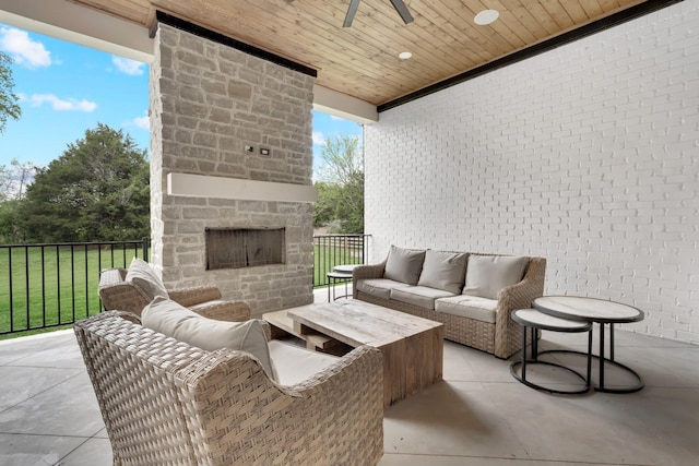view of patio with a ceiling fan and an outdoor living space with a fireplace