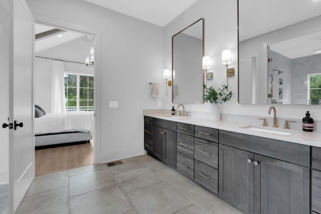 ensuite bathroom featuring double vanity, a sink, walk in shower, and ensuite bath