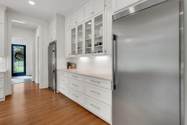 kitchen with light countertops, high end fridge, stainless steel built in refrigerator, and white cabinets