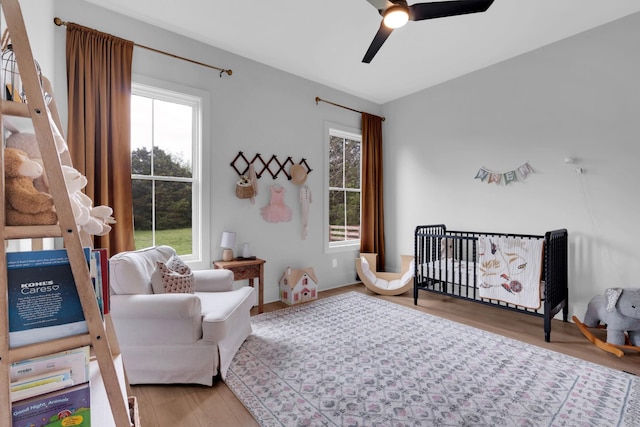 bedroom with multiple windows, a ceiling fan, and wood finished floors