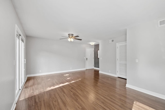 unfurnished living room with baseboards, ceiling fan, visible vents, and wood finished floors