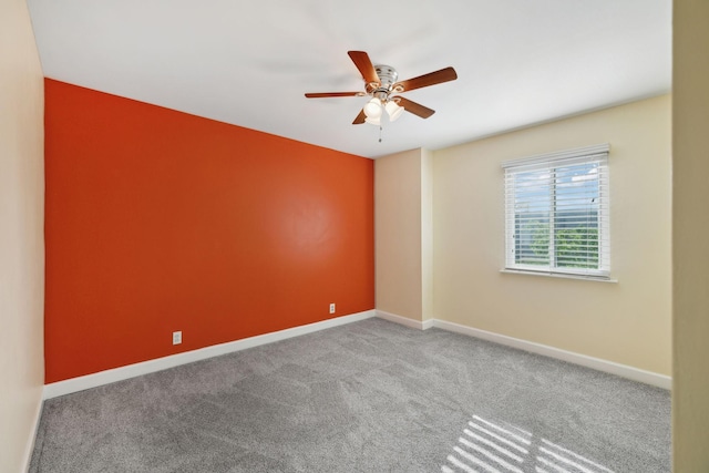 spare room with baseboards, ceiling fan, and carpet