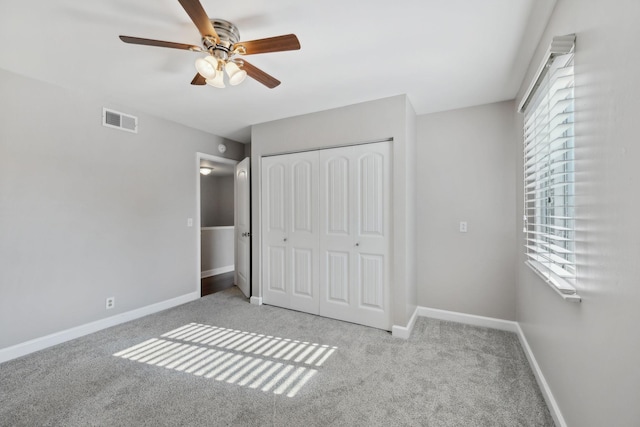 unfurnished bedroom with a ceiling fan, visible vents, baseboards, a closet, and carpet