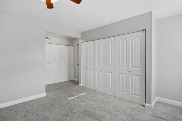 unfurnished bedroom featuring baseboards, a ceiling fan, carpet flooring, and visible vents