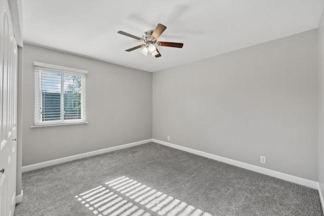 spare room with carpet floors, a ceiling fan, and baseboards