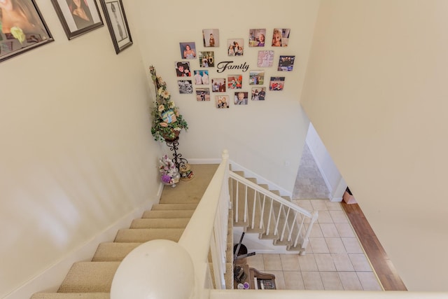 stairway featuring baseboards and tile patterned floors