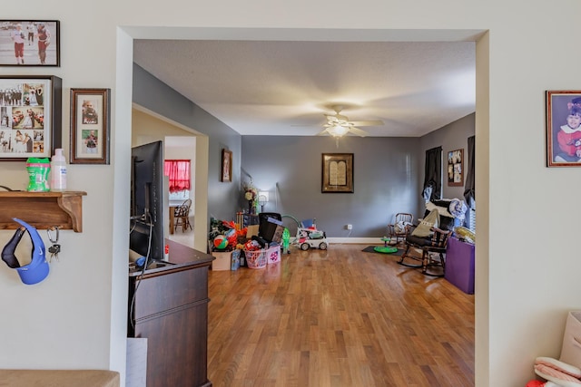 playroom featuring a ceiling fan and wood finished floors